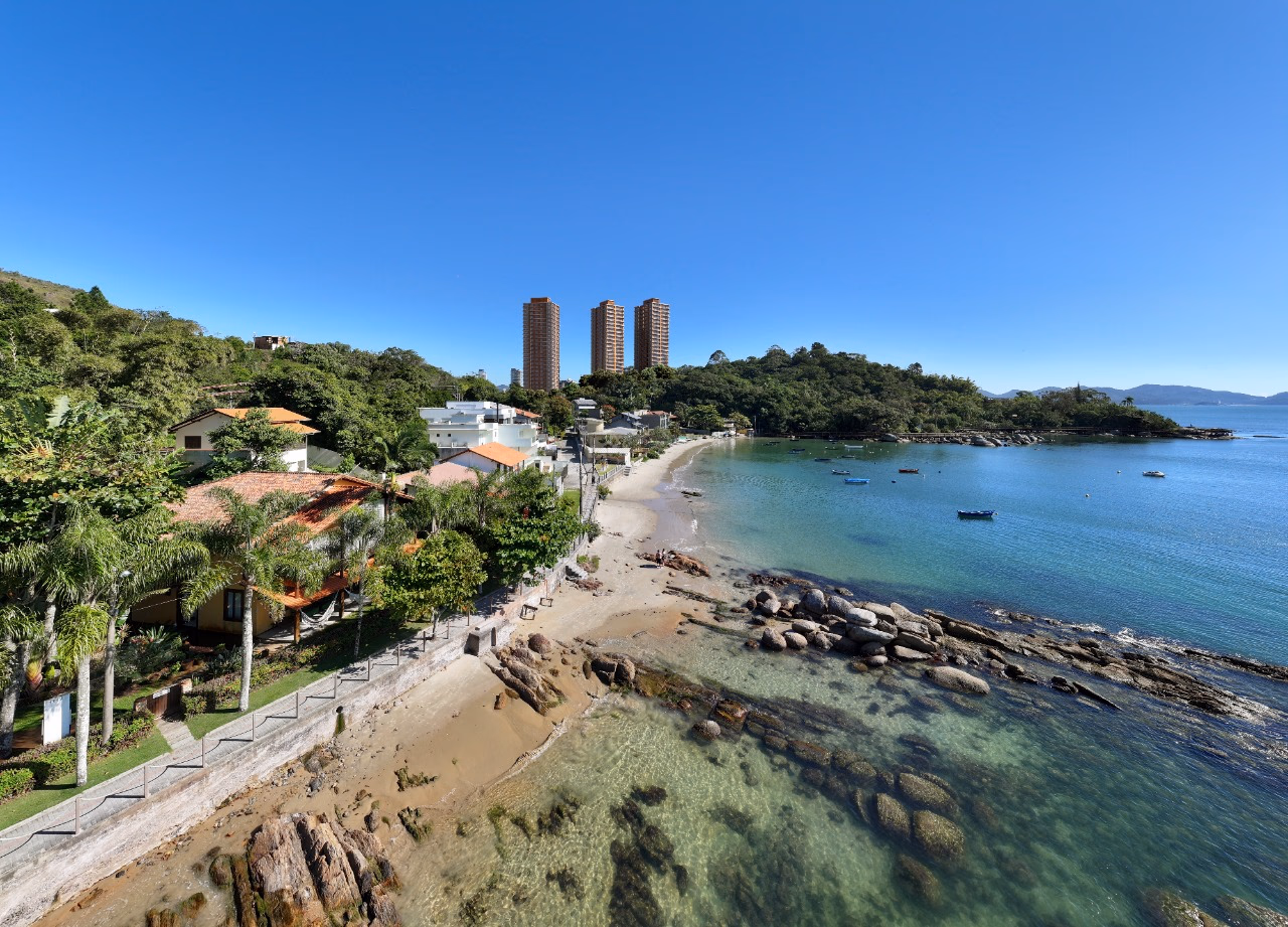 A enseada, o costão e as torres ao fundo, vistos do calçadão