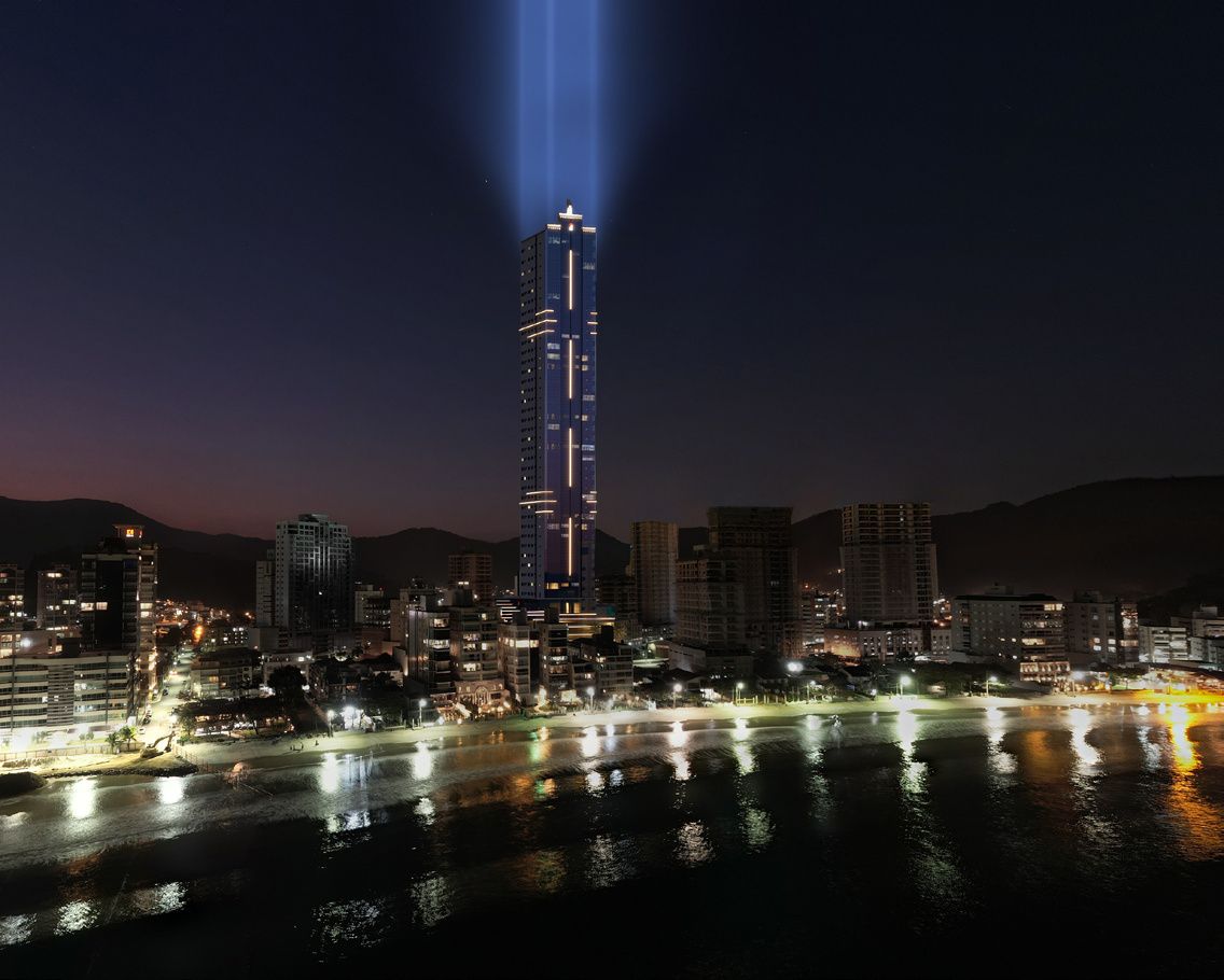 Torre iluminada do Accendis Home Living sobre a orla do Centro de Itapema, à noite