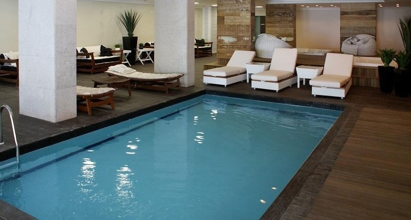 Segunda piscina coberta, com lounge e espreguiçadeiras, no Atlantic Paradise Towers, Itapema
