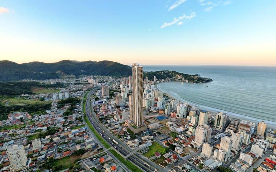 Vista aérea de Itapema ao pôr do sol, com a torre do Empire 234