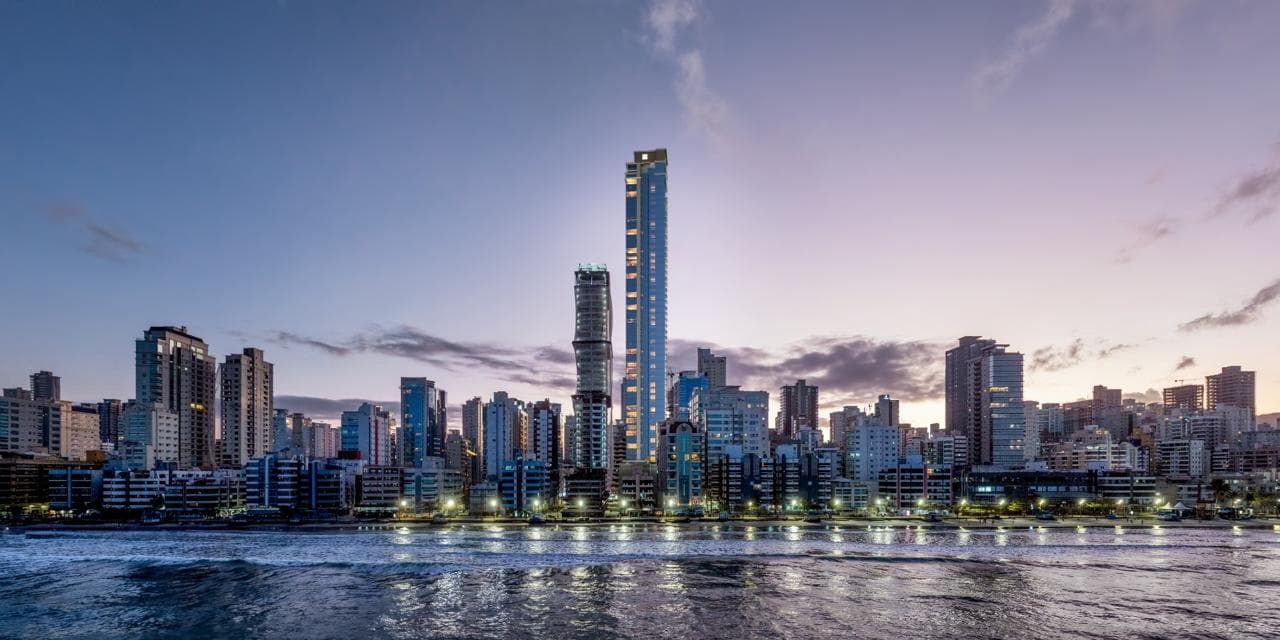Evolution Residence no skyline de Meia Praia, Itapema/SC — torre com vista para o mar iluminada ao entardecer