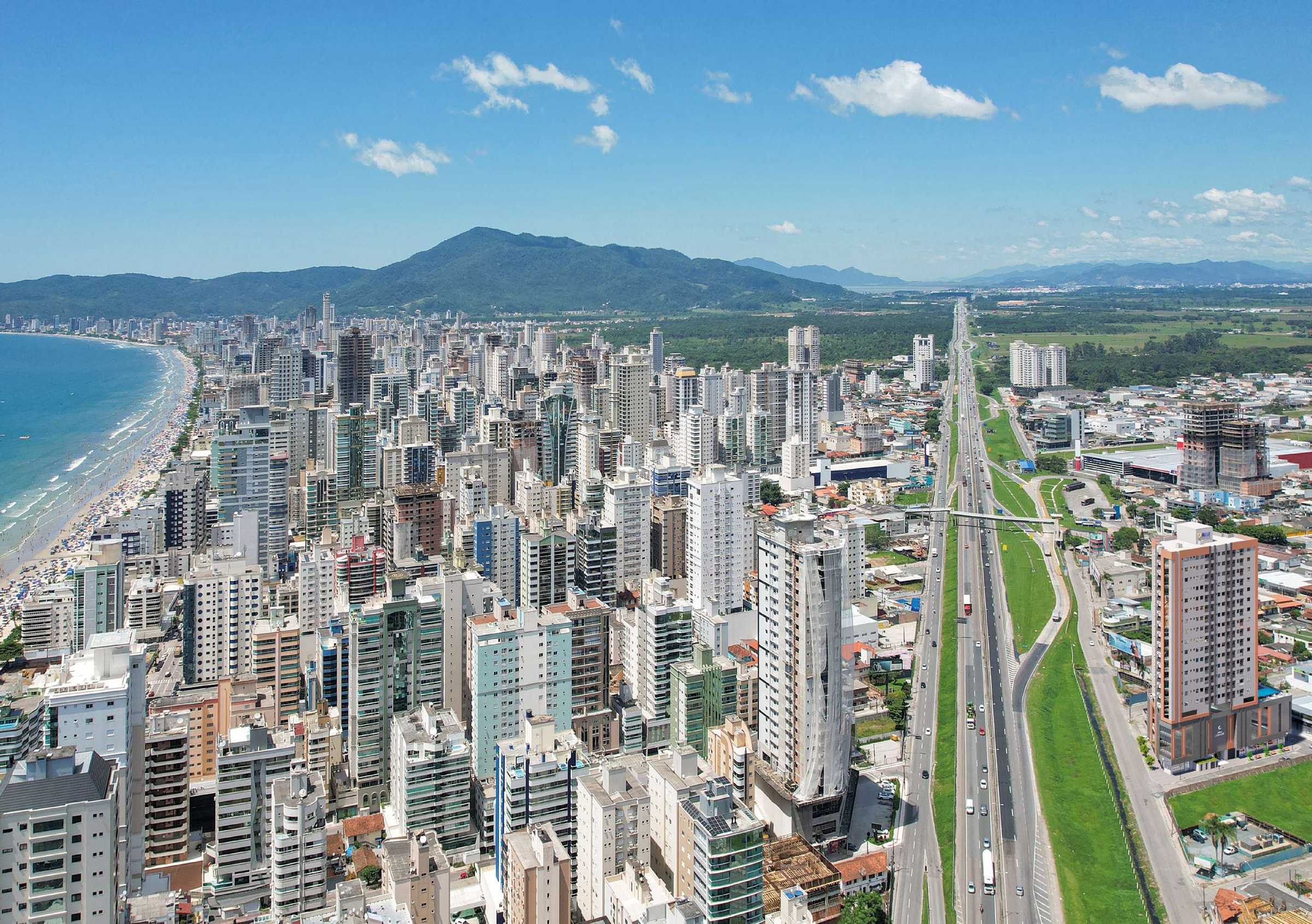 Vista aérea de Itapema, com a praia, a cidade e a BR-101