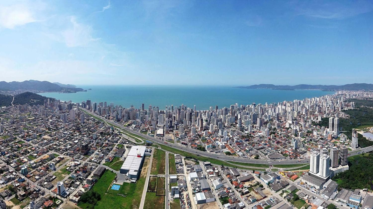 Vista aérea da Meia Praia mostrando a localização do Le Chloe na 2ª Avenida, com o mar de Itapema