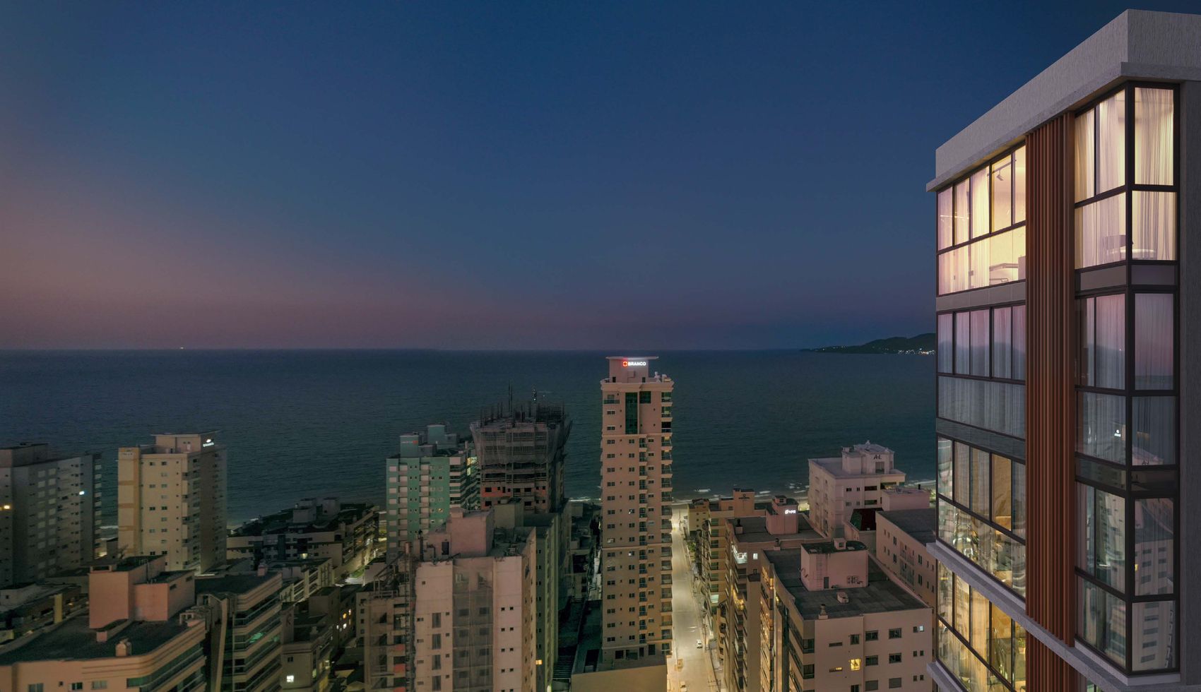 Torre do The Breeze no skyline da Meia Praia ao entardecer, com o mar ao fundo, em Itapema